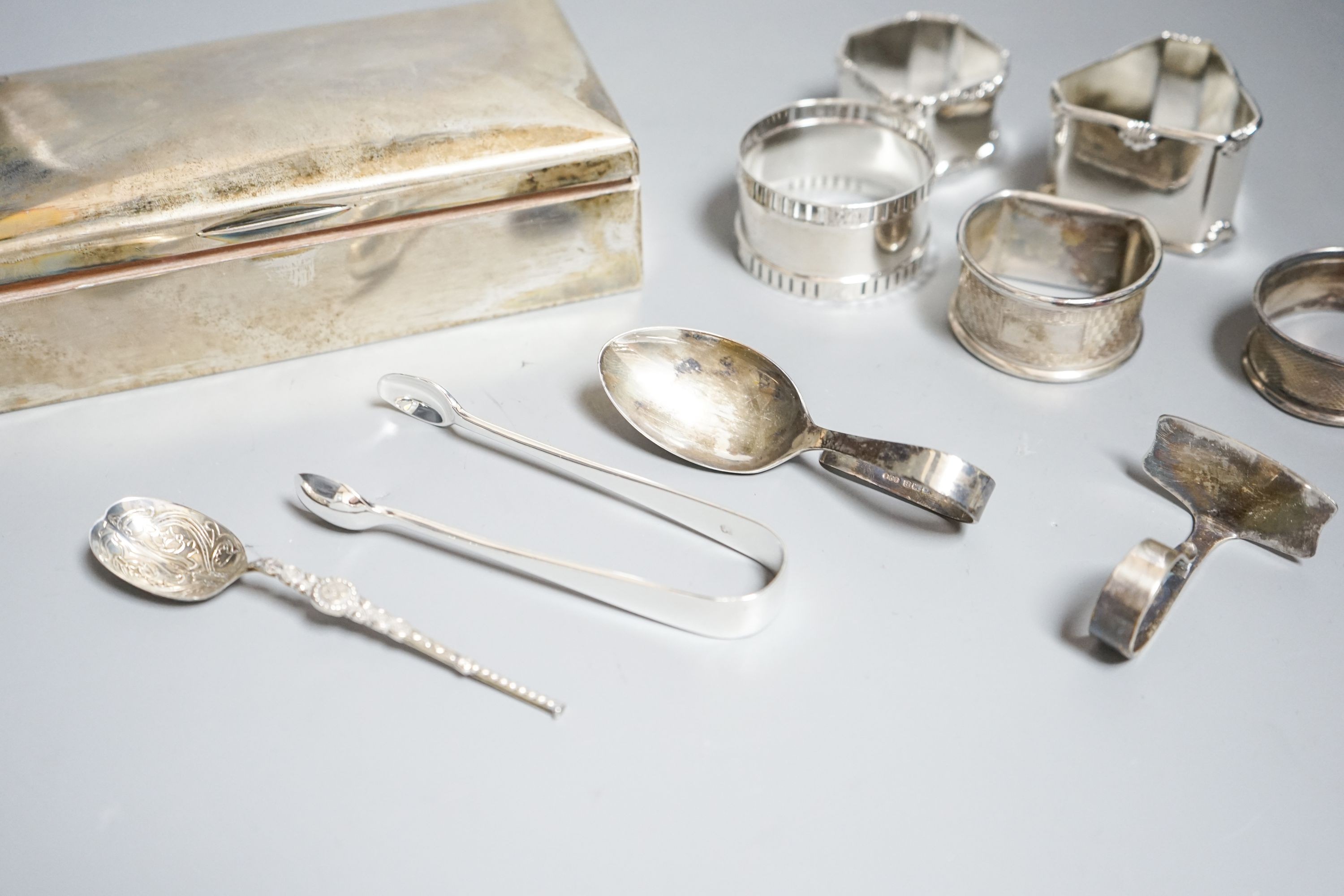 Small silver including a German 800 mounted cigarette box, five napkin rings, spoons etc.